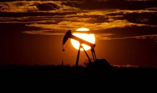 The sun sets behind an idle pump jack near Karnes City, USA, April 8, 2020.  Oil markets have been fluctuating over fears of lost supplies from Russia because of the war in Ukraine. But the alliance of OPEC members and allied oil-producing countries are likely to steer a steady course when they decide production levels at an online meeting Thursday. The OPEC+ alliance has been opening the taps only gradually to restore cuts made during the worst of the pandemic recession. (AP Photo/Eric Gay, Fil
