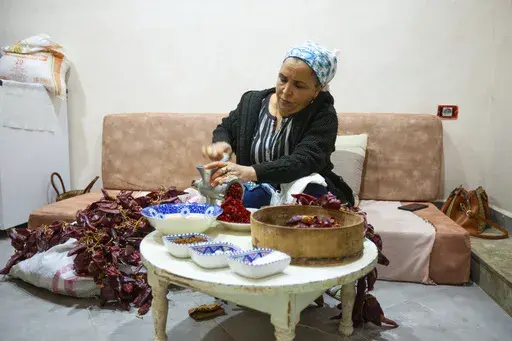 Chahida Boufaied, owner of Dar Chahida Lel Oula, prepares the Harissa in her house in Nabeul, Tunisia, Jan. 7, 2025. (AP Photo/Ons Abid)
