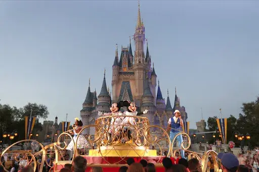 Mickey and Minnie Mouse perform during a parade as they pass by the Cinderella Castle at the Magic Kingdom theme park at Walt Disney World in Lake Buena Vista, Fla.  The theme park resort announced Tuesday, Feb. 15, 2022, that face coverings will be optional for fully-vaccinated visitors in all indoor and outdoor locations, with one exception. Face masks still will be needed for visitors ages 2 and older on enclosed transportation, such as the resort's monorail, buses and the resort's sky gondol
