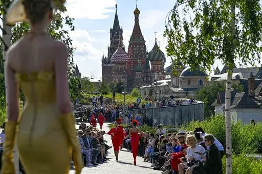 A model displays the collection by Russian designer Slava Zaitsev during the opening of the Fashion Week in at Zaryadye Park with the Spasskaya Tower and St. Basil's Cathedral in the background near Red Square in Moscow, Russia, on June 20, 2022. Luxury spending is growing faster than ever, fueled by pent-up pandemic demand and shifting demographics as younger, more diverse consumers buy into tiny handbag and post-streetwear trends, according to a new study by Bain consultancy released on Tuesda