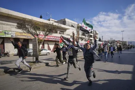 Syrians celebrate the fall of Bashar Assad's government in the town of Bar Elias, Lebanon, near the border with Syria, Sunday, Dec. 8, 2024. (AP Photo/Hassan Ammar, File)