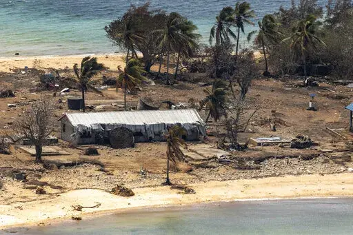 In this photo provided by the Australian Defence Force debris from damaged building and trees are strewn around on Atata Island in Tonga, Jan. 28, 2022, following the eruption of an underwater volcano and subsequent tsunami. The international aid Tonga accepted after the disaster has caused the country's first COVID-19 outbreak, and there are worries the isolation that kept Tonga and other Pacific nations virus-free until now will hurt their ability to manage the public health threat.(POIS Chris
