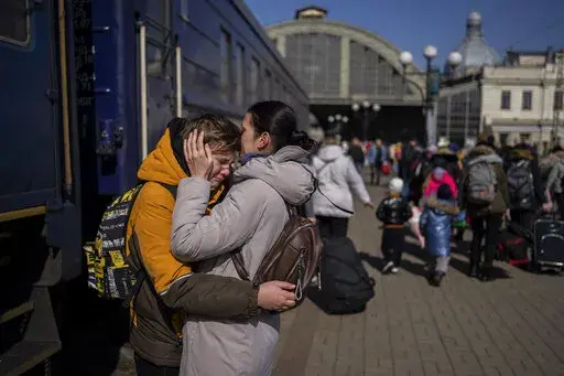 A mother embraces her son who escaped the besieged city of Mariupol and arrived at the train station in Lviv, western Ukraine on Sunday, March 20, 2022. (AP Photo/Bernat Armangue)