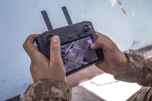 A Ukrainian soldier looks at a drone screen showing Russian troops positions during heavy fighting at the front line in Severodonetsk, Luhansk region, Ukraine, Wednesday, June 8, 2022. (AP Photo/Oleksandr Ratushniak)