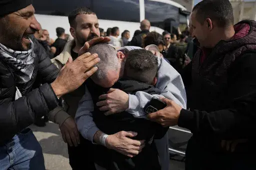 Palestinian prisoners are greeted as they exit a Red Cross bus after being released from Israeli prison following a ceasefire agreement between Israel and Hamas, in the West Bank city of Ramallah, Saturday Feb. 1, 2025. (AP Photo/Nasser Nasser)