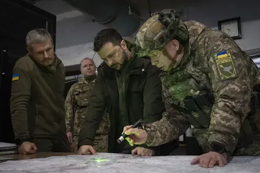 Ukrainian President Volodymyr Zelenskyy, Commander of Ukraine's Ground Forces Col.-Gen. Oleksandr Syrsky, right, and Roman Mashovets, deputy head of the Presidential Office, look at a map during their visit to the front-line city of Kupiansk, Kharkiv region, Ukraine, Thursday, Nov. 30, 2023. Zelenskyy says the war with Russia is in a new stage, with winter expected to complicate fighting after a summer counteroffensive that failed to produce desired results due to enduring shortages of weapons a