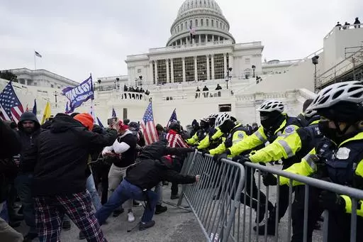 Violent insurrectionists loyal to then-President Donald Trump try to break through a police barrier, Wednesday, Jan. 6, 2021, at the Capitol in Washington. (AP Photo/Julio Cortez, File)
