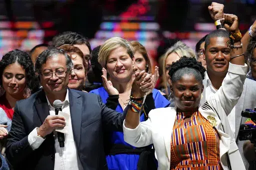 Former rebel Gustavo Petro, left, his wife Veronica Alcocer, back center, and his running mate Francia Marquez, celebrate before supporters after winning a runoff presidential election in Bogota, Colombia, Sunday, June 19, 2022. (AP Photo/Fernando Vergara)
