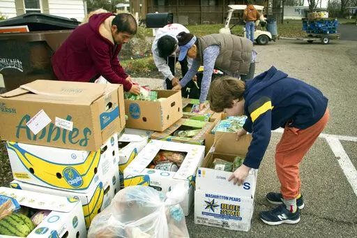 In this image provide by Last Mile Food Rescue, food is distributed at a Last Mile Food Rescue pop-up food pantry in a Cincinnati parking lot in November, 2021 Nonprofits of all kinds are getting hit hard by inflation, experts say. (Denise Johnson/Last Mile Food Rescue via AP)