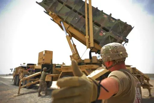 In this photo released by the U.S. Air Force, U.S. Army Spc. Scottlin Bartlett of the 5-52 Air Defense Artillery Battalion signals to a colleague while working near a Patriot missile battery at Al-Dhafra Air Base in Abu Dhabi, United Arab Emirates, May 5, 2021. The wars of the wider Middle East that long surrounded the United Arab Emirates now have encroached into daily life in this U.S.-allied nation, threatening to draw America further into a region inflamed by tensions with Iran. Al-Dhafra ha
