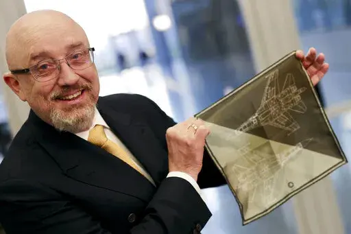 CAPTION CORRECTS THE ID - Ukraine's Defense Minister Oleksiy Reznikov shows a handkerchief with a F-35 fighter jet when heading to a meeting with United States Secretary of Defense Lloyd Austin, on the sidelines of a NATO headquarters in Brussels, Tuesday, Feb. 14, 2023. (AP Photo/Olivier Matthys, Pool)