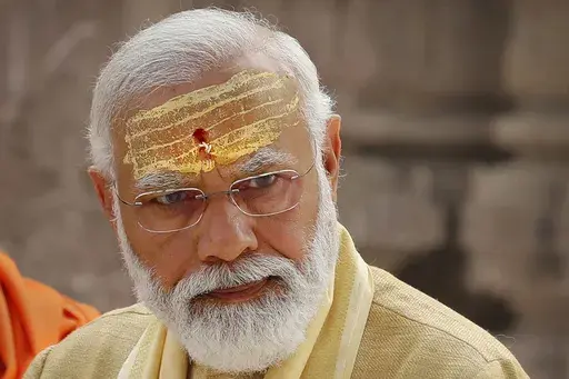 FILE- Indian Prime Minister Narendra Modi has sandalwood paste and vermilion applied on his forehead during the inauguration of Kashi Vishwanath Dham Corridor, a promenade that connects the Ganges River with the centuries-old temple dedicated to Hindu god Shiva in Varanasi, India, Dec. 13, 2021. Hindu nationalism, once a fringe ideology in India, is now mainstream. Nobody has done more to advance this cause than Modi, one of India’s most beloved and polarizing political leaders. (AP Photo/Raje