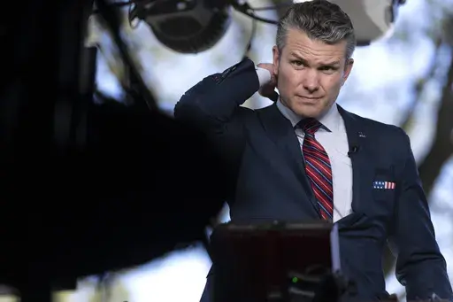 Defense Secretary Pete Hegseth prepares to give a television interview outside the White House, Friday, March 21, 2025, in Washington. (AP Photo/Mark Schiefelbein)