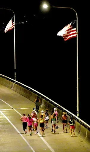 A group of runners cross the Veteran's Bridge as they return to Girls Preparatory School as they take part in  "Finish Eliza's Run" on Friday, Sept. 9, 2022 in Chattanooga, Tenn. The approximately four mile run was to memorialize, Eliza Fletcher, the Memphis runner, and mother of two, who was murdered during her early morning run.   (Robin Rudd /Chattanooga Times Free Press via AP)