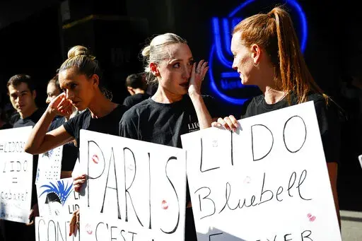 Lido cabaret employees react during a demonstration to try to save their jobs and the history of the cabaret, known for its dinner theater and its "Bluebell Girls" revue, Saturday, May 28, 2022 in Paris. Amid financial troubles and changing times, the venue's new corporate owner is ditching most of the Lido's staff and its high-kicking, high-glamour dance shows — which date back decades and inspired copycats from Las Vegas to Beirut — in favor of more modest musical revues. (AP Photo/Thomas 
