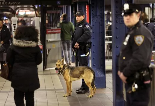 Police officers patrol in the passageway connecting New York City's Port Authority bus terminal and the Times Square subway station, Dec. 12, 2017. New York City plans to intensify a crackdown on subway fare-beating by sending at least 800 police officers specifically to keep watch on turnstiles, officials announced Monday, March 25, 2024. (AP Photo/Seth Wenig, File)