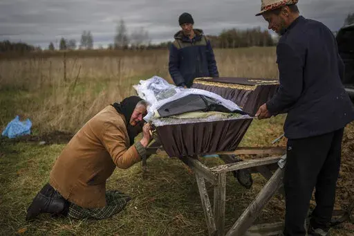 Nadiya Trubchaninova cries over the coffin of her son, Vadym, who was killed on March 30 by Russian soldiers in Bucha, Ukraine, during his funeral in the cemetery of nearby Mykulychi, on the outskirts of Kyiv, on April 16, 2022. Nobody knows how many civilians have died in the 100 days since Russia's invasion of Ukraine, but one thing is certain: the toll reaches into the tens of thousands. (AP Photo/Rodrigo Abd, File)