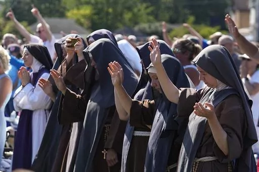 Attendees pray during a "rosary rally" on Sunday, Aug. 6, 2023, in Norwood, Ohio. As the campaigning for and against the nation’s latest tug-of-war over abortion begins in earnest this weekend, Ohio voters are getting a different message from the measure’s opponents. (AP Photo/Darron Cummings, File)