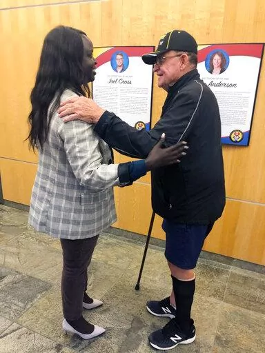 Nyamal Dei, a school board member in Fargo, N.D., is greeted by Vietnam veteran David Halcrow following a special meeting on Thursday, Aug. 18, 2022, to reconsider a decision by the previous board to eliminate reciting the Pledge of Allegiance before meetings. Halcrow apologized to Dei for a barrage of hate emails and voicemails she received following last week’s decision to ax the pledge. Dei, the lone Black member on the board, was the only person to vote Thursday against reinstating the ple
