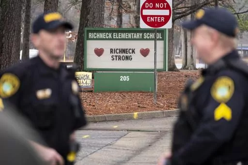 Police look on as students return to Richneck Elementary on Jan. 30, 2023, in Newport News, Va. A grand jury in Virginia has indicted the mother of a 6-year-old boy who shot his teacher on charges of child neglect and failing to secure her handgun in the family's home, a prosecutor said Monday, April 10. (Billy Schuerman/The Virginian-Pilot via AP, File)
