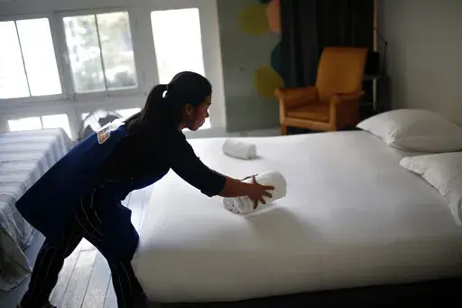 In this Thursday, Sept. 20, 2018 photo, a cleaning lady works in an apartment located on Airbnb in Paris.  Airbnb hosts are facing an onslaught of frustrations born of renting out their properties to short-term guests. Certain guests have proven disrespectful of hosts’ homes, with some squatting illegally — and getting away with it — and others trashing properties with Silly String, feces and more.  (AP Photo/Thibault Camus, file)