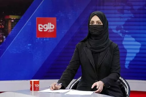 Khatereh Ahmadi a TV anchor wears a face covering as she reads the news on TOLO NEWS, in Kabul, Afghanistan, Sunday, May 22, 2022. Afghanistan's Taliban rulers have begun enforcing an order requiring all female TV news anchors in the country to cover their faces while on-air. The move Sunday is part of a hard-line shift drawing condemnation from rights activists. (AP Photo/Ebrahim Noroozi)