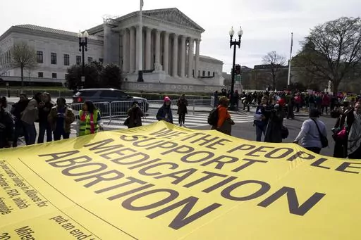 Abortion rights activists unfurl a banner, created by the ACLU, filled with names of people who said they support the continued access to medication abortion, outside the Supreme Court, Tuesday, March 26, 2024, in Washington. The Supreme Court is hearing arguments in its first abortion case since conservative justices overturned the constitutional right to an abortion two years ago. At stake in Tuesday's arguments is the ease of access to a medication used last year in nearly two-thirds of U.S. 