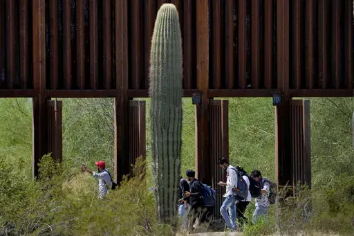 A group claiming to be from India walk past open border wall storm gates after crossing through the border fence in the Tucson Sector of the U.S.-Mexico border, Aug. 29, 2023, in Organ Pipe Cactus National Monument near Lukeville, Ariz. (AP Photo/Matt York, File)