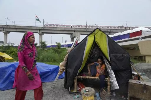 People evacuated from the flood plains of the river Yamuna rest in makeshift tents along a street in New Delhi, India, Thursday, July 13, 2023. Residential areas close to the river were flooded, submerging roads, cars and homes, leading to the evacuation of thousands of people from low-lying areas in the country's capital city. More than 100 people were killed this week after record monsoon rains led to massive waterlogging, road caves-in, collapsed homes and gridlocked traffic, officials said T