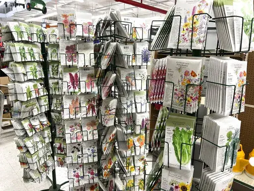 This Jan. 23, 2022 image provided by Jeff Lowenfels shows seed packets for sale on in Anchorage, Alaska. Seed racks are back in stores promising all kinds of abundance in the gardening season ahead. Be careful approaching them, those seed packets can lure you in with pretty pictures on the front. But it's the advice on the back you need to follow. (Jeff Lowenfels via AP)
