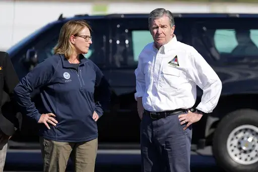 FILE- North Carolina Gov. Roy Cooper, right, and Deanne Criswell, Administrator of the U.S. Federal Emergency Management Agency, await the arrival of Democratic presidential nominee Vice President Kamala Harris for a briefing on the damage from Hurricane Helene, at Charlotte Douglas International Airport, Oct. 5, 2024, in Charlotte, N.C. (AP Photo/Chris Carlson, file)