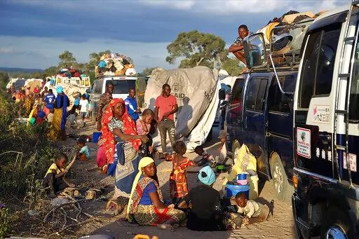 This undated photo provided on Thursday, Oct. 13, 2022 by Doctors Without Borders (MSF) shows people displaced by the conflict in Cabo Delgado Province Mozambique, next to a truck on the outskirts of Mueda, Mozambique, waiting to be transported to reach Palma, a coastal town that was attacked earlier this year and where some people have already gradually returned. Fleeing beheadings, shootings, rapes and kidnappings, nearly 1 million people are displaced by the Islamic extremist insurgency in no