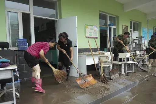 In this photo released by Xinhua News Agency, teachers clean classrooms at a school in the aftermath of flood waters from an overflowing river in Qizhongkou Town of Laishui County in north China's Hebei Province on Aug. 11, 2023. A vast swath of northeastern China is threatened by flooding as at least 90 rivers have risen above warning levels and 24 have already overflowed their banks. State media say crews are standing by to defend homes and farmland across the Songliao Basin north of Beijing w