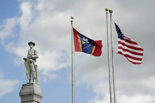 The Mississippi state and U.S. flags fly near the Rankin County Confederate Monument in the downtown square of Brandon, Miss., on March 3, 2023. Mississippi and Alabama closed most government offices Monday, April 24, for Confederate Memorial Day as efforts have stalled to abolish state holidays that honor the old Confederacy. (AP Photo/Rogelio V. Solis, File)