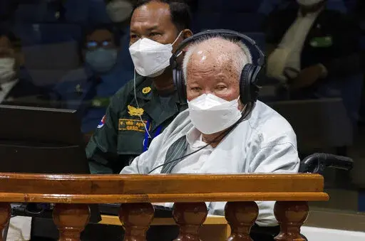 In this photo released by the Extraordinary Chambers in the Courts of Cambodia, Khieu Samphan, right, the former head of state for the Khmer Rouge, sits in a courtroom during a hearing at the U.N.-backed war crimes tribunal in Phnom Penh, Cambodia, Thursday, Sept. 22, 2022. The international court convened in Cambodia to judge the brutalities of the Khmer Rouge regime that caused the deaths of an estimated 1.7 million people in the 1970s ends its work Thursday after spending $337 million and 16 