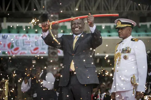 Kenya's new president William Ruto holds up a ceremonial sword as he is sworn in to office at a ceremony held at Kasarani stadium in Nairobi, Kenya Tuesday, Sept. 13, 2022. William Ruto was sworn in as Kenya's president on Tuesday after narrowly winning the Aug. 9 election and after the Supreme Court last week rejected a challenge to the official results by losing candidate Raila Odinga. (AP Photo/Brian Inganga)
