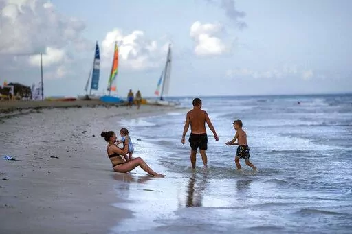 Tourists are seen along the beach at the Iberostar Selection Varadero hotel in Varadero, Cuba, on Sept. 29, 2021. The Biden administration announced Monday that it will expand flights to Cuba and lift Donald Trump-era restrictions on remittances that immigrants can send to people on the island. (AP Photo/Ramon Espinosa, File)