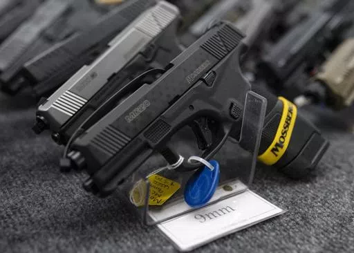 Pistols sit on display during the first day of the Silver Spur Gun and Blade Show, Jan. 22, 2022, in Odessa, Texas. On Monday, May 20, 2024, a federal judge blocked the Biden administration from enforcing a new rule in Texas that would require firearms dealers to run background checks on buyers at gun shows or other places outside brick-and-mortar stores. (Eli Hartman/Odessa American via AP, File)