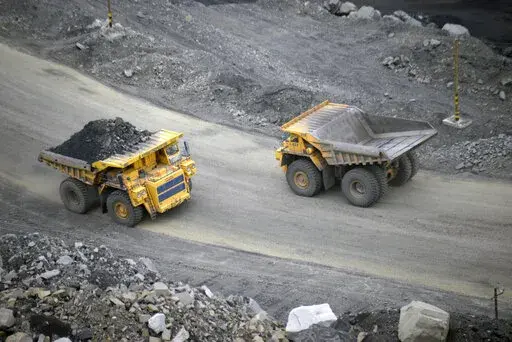 A loaded dump truck passes an empty truck as it carries away coal at the Kedrovsky open-pit coal mine in Kemerovo, Russia, Tuesday, June 16, 2015. Poland’s government has decided to block imports of coal from Russia. The move is an element in a larger strategy to reduce energy dependence on Russia which gained new urgency after the invasion of Ukraine. The government of Prime Minister Mateusz Morawiecki agreed to impose financial penalties on the private entities importing Russian coal into Po