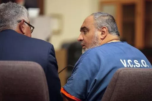 Attorney Ron Bamieh, left, listens to his client, Loay Abdelfattah Alnaji, a professor of computer science at Moorpark College, in Ventura County Superior Court on Nov. 17, 2023, in Ventura, Calif. A judge decided Wednesday, May 15, that Alnaji will stand trial for involuntary manslaughter and battery in the death of a Jewish counter-protester during demonstrations over the Israel-Hamas war last year. (AP Photo/Damian Dovarganes, File)