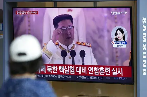 A woman watches a TV screen showing a news program reporting about North Korea's missile launch with a file footage of North Korean leader Kim Jong Un, at a train station in Seoul, South Korea, Sunday, June 5, 2022. North Korea test-fired a salvo of multiple short-range ballistic missiles toward the sea on Sunday, South Korea's military said, extending a provocative streak in weapons demonstrations this year that U.S. and South Korean officials say may culminate with a nuclear test explosion. (A