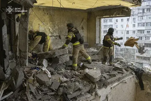 In this photo provided by the Ukrainian Emergency Service, rescuers search for civilians who were killed when a Russian drone hit an apartment building in Sumy, Ukraine, Thursday, Jan. 30, 2025. (Ukrainian Emergency Service via AP)