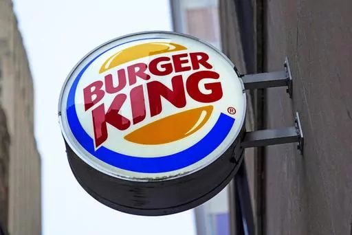 The Burger King logo is displayed on a sign outside a restaurant in downtown Pittsburgh, Jan. 12, 2022. Food ads have long made their subjects look bigger, juicier and crispier than they are in person. But some consumers say those mouthwatering ads can cross the line into deception, and that’s leading to a growing number of lawsuits. Burger King is the latest company in the crosshairs. (AP Photo/Gene J. Puskar, File)