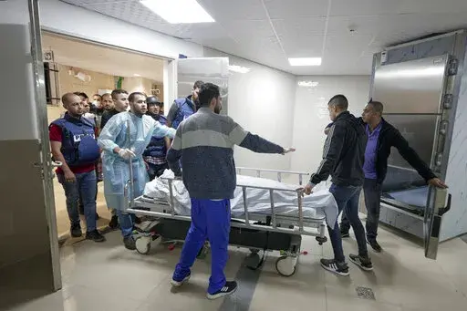 Journalists and medics wheel the body of Shireen Abu Akleh, a journalist for Al Jazeera network, into the morgue inside the Hospital in the West Bank town of Jenin, Wednesday, May 11, 2022. The well-known Palestinian reporter for the broadcaster's Arabic language channel was shot and killed while covering an Israeli raid in the occupied West Bank town of Jenin early Wednesday, the Palestinian health ministry said. (AP Photo/Majdi Mohammed)