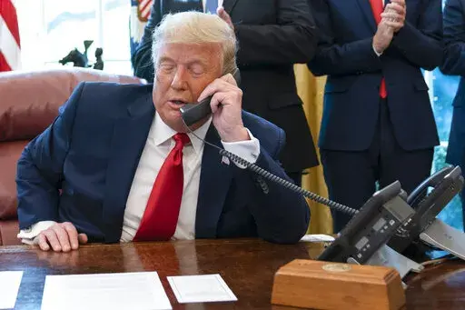 In this Oct. 23, 2020, photo, President Donald Trump talks on a phone during a call with the leaders of Sudan and Israel in the Oval Office of the White House, in Washington. White House call logs obtained so far by the House panel investigating the Jan. 6, 2021 insurrection at the Capitol do not list calls made by then-President Donald Trump as he watched the violence unfold on television. They also do not list calls made directly to the president, according to two people familiar with the prob
