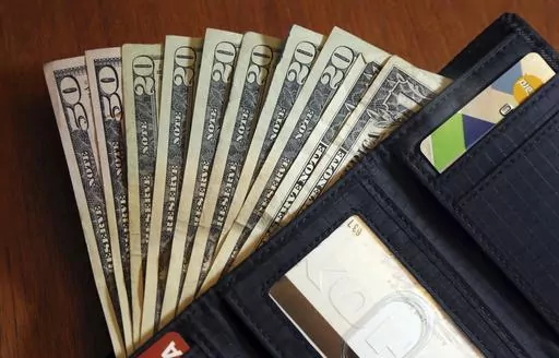 In this June 15, 2018, file photo, cash is fanned out from a wallet in North Andover, Mass. Having the right amount of financial confidence, or belief in our money-related abilities, can help us make better financial decisions, experts say. Building financial confidence starts with developing a basic working knowledge of budgeting, saving and investing. Finding a supportive community and place where you can ask questions also helps. (AP Photo/Elise Amendola, File)