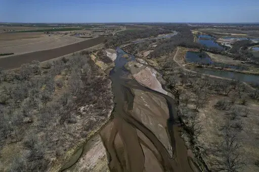 The South Platte River flows on Thursday, April 28, 2022, in Fort Morgan, Colo. As climate change-fueled megadrought edges eastward, Nebraska wants to divert water in Colorado by invoking an obscure, 99-year-old compact between the states that allows Nebraska to seize Colorado land along the South Platte River to build a canal. (AP Photo/Brittany Peterson)