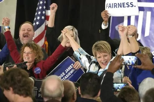 Supreme Court candidate Janet Protasiewicz, right, holds hands with Wisconsin Supreme Court Justice Rebecca Dallet, left, and Wisconsin Supreme Court Justice Ann Walsh Bradley, blocked from view at far right, at a watch party in Milwaukee, on April 4, 2023. The Wisconsin's Supreme Court flips from majority conservative to liberal control on Aug. 1 when Protasiewicz is set to be sworn in. (Mike De Sisti/Milwaukee Journal-Sentinel via AP, File)
