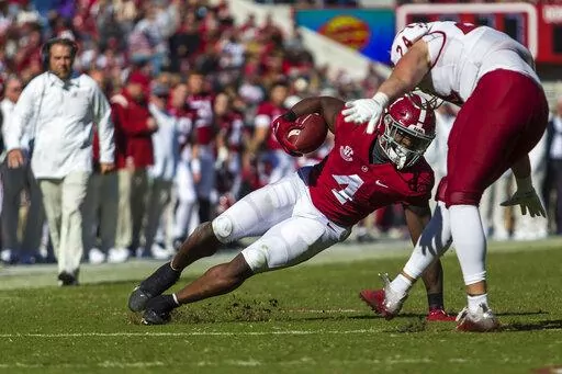 Alabama running back Brian Robinson Jr. (4) makes a hard cut on a run as New Mexico State linebacker Nick Giacolone (24) pursues during the first half of an NCAA college football game, Saturday, Nov. 13, 2021, in Tuscaloosa, Ala. (AP Photo/Vasha Hunt)