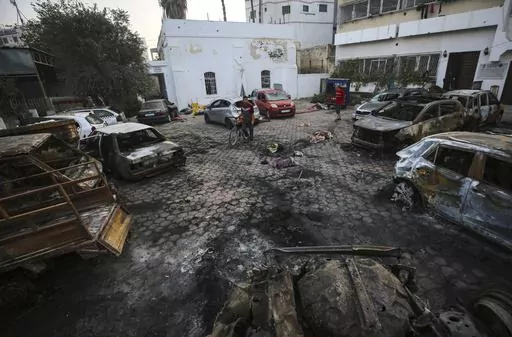 Men look over the site of a deadly explosion at Al-Ahli Hospital in Gaza City, Wednesday, Oct. 18, 2023. This photo and others taken the morning after the explosion show no evidence of a large crater at the impact site that would be consistent with a large bomb such as those dropped by Israeli aircraft in other recent strikes. (AP Photo/Abed Khaled, File)
